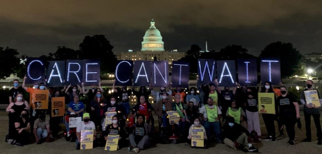 People posing in DC, with the US Capitol Building in the background, holding a banner that reads: "Care Can't Wait"